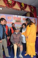 Swamiji distributing assistive devices and necessary equipments to differently abled people