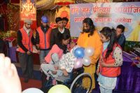 Swamiji distributing assistive devices and necessary equipments to differently abled people