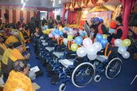 Swamiji distributing assistive devices and necessary equipments to differently abled people